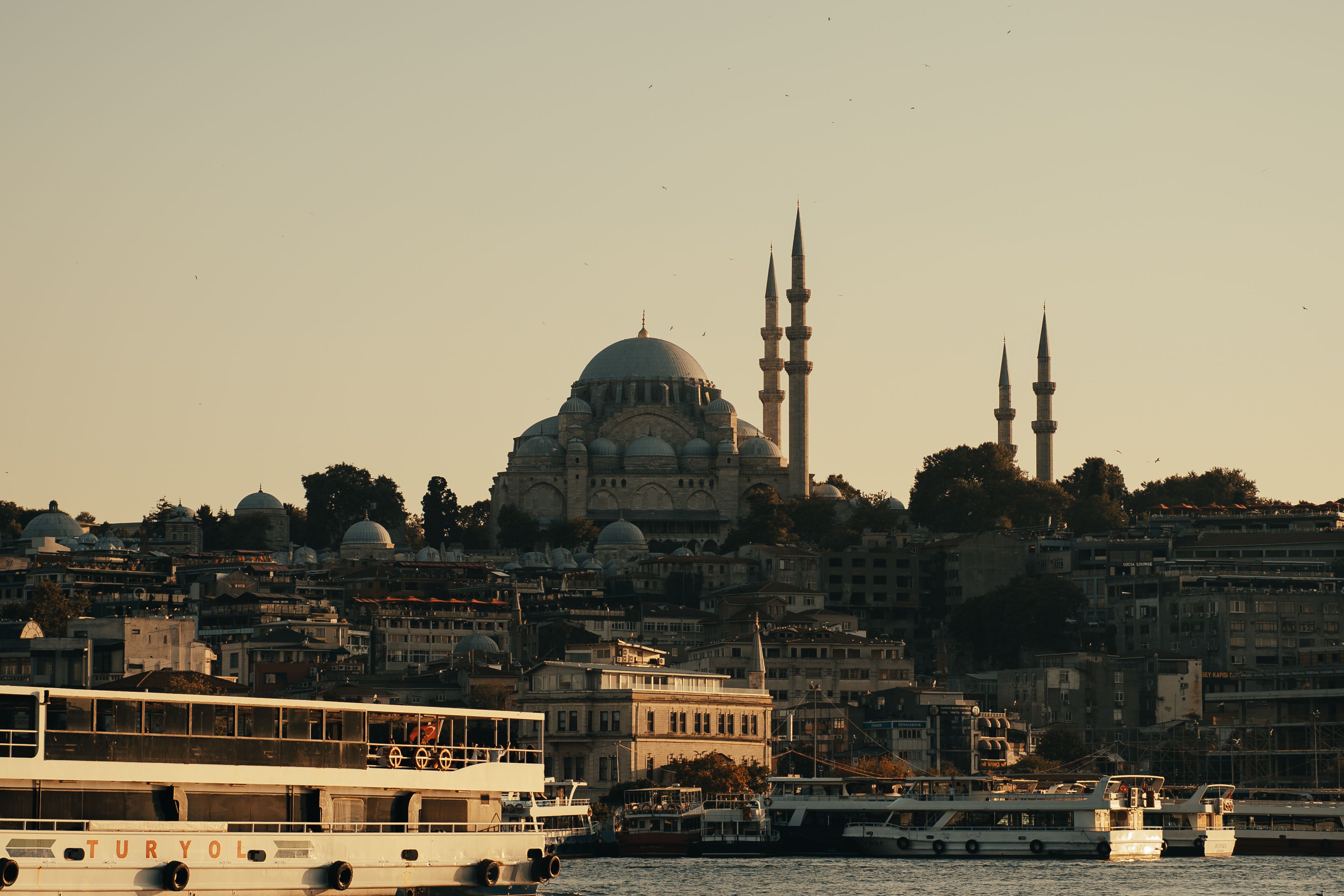 Suleymaniye Mosque above passenger ferries on Istanbul's waterfront at sunset